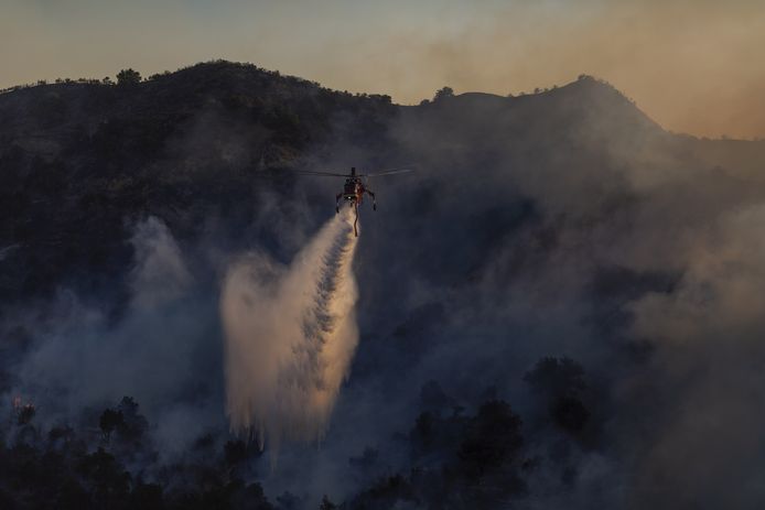 NEWHALL, CA - OCTOBER 11: A firefighting helicopter drops water on the Saddleridge Fire on October 11, 2019 near Newhall, California. The fire has spread to 7500 acres and burned at least two dozen homes   David McNew/Getty Images/AFP
== FOR NEWSPAPERS, INTERNET, TELCOS & TELEVISION USE ONLY ==