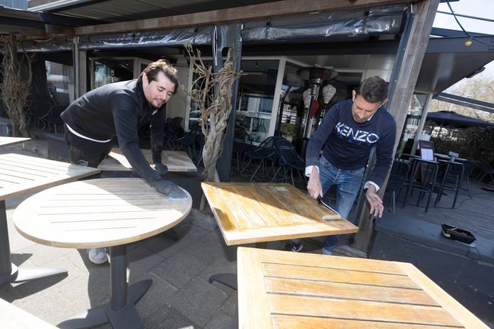 René Peters en Mirzah Durmit van restaurant Lodewijk schuren en schilderen de tafeltjes zodat het er weer top uitziet als volgende week de terrassen weer opengaan.