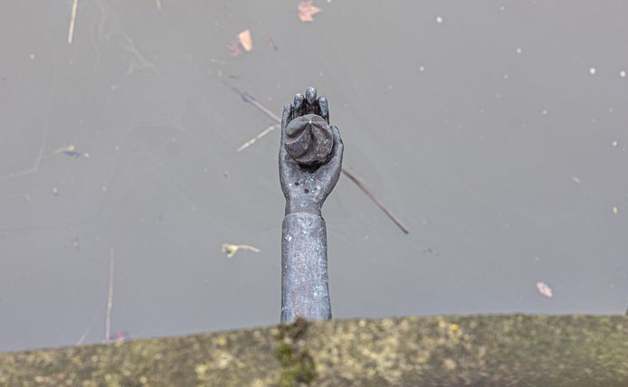 Wie goed kijkt, ziet een bronzen hand uit de muur steken onder de Sassenpoorterbrug.