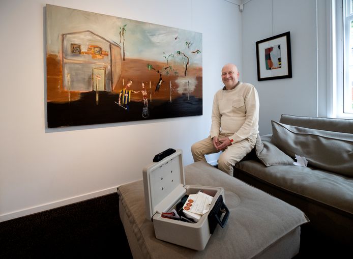 Peter Metzemaekers met zijn geldkistje, voor een schilderij van Jeroen Vrijsen.