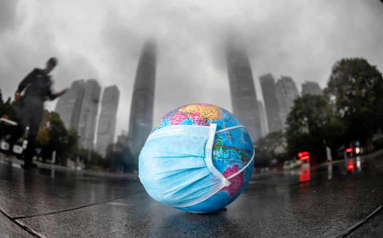 Een mini-wereldbol met een mondmasker in Guangzhou, China. Beeld EPA
