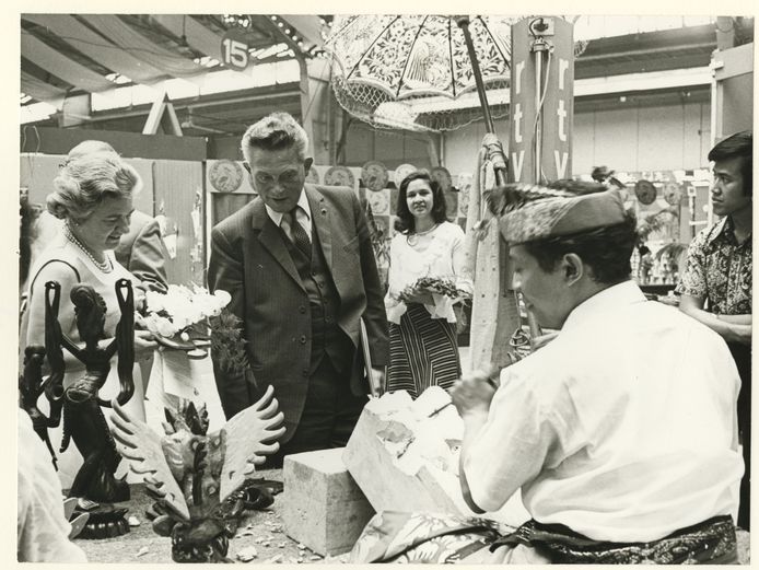 Burgemeester Vic Marijnen opent in 1973 de 15e Pasar Malam in de Houtrusthallen. Links zijn eega Miny Marijnen, op de achtergrond, met bloemstuk: Pasardirecteur Ellen Derksen,