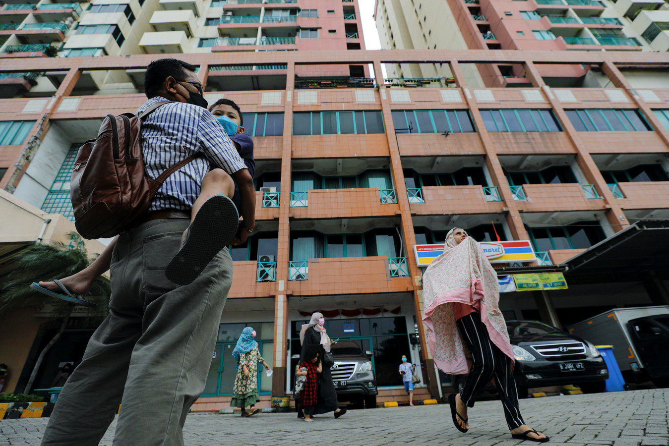 Un homme porte un enfant alors que des personnes évacuent un immeuble à la suite d'un tremblement de terre à Jakarta, en Indonésie, le 14 janvier 2022.