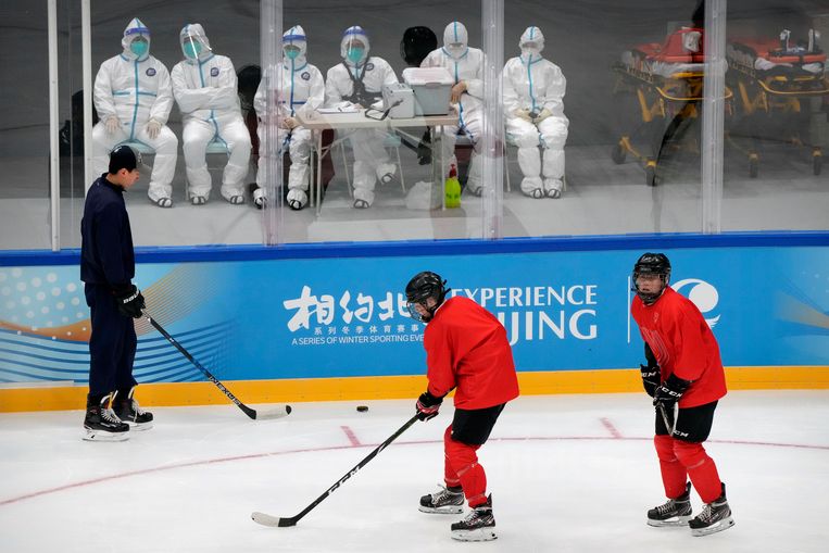 Medisch personeel kijkt toe het het Chinese ijshockeyteam traint in aanloop naar de Winterspelen over twee maanden. Beeld AP