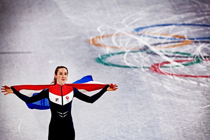 Suzanne Schulting rijdt na haar laatste race in Peking over het ijs met een Nederlandse vlag.