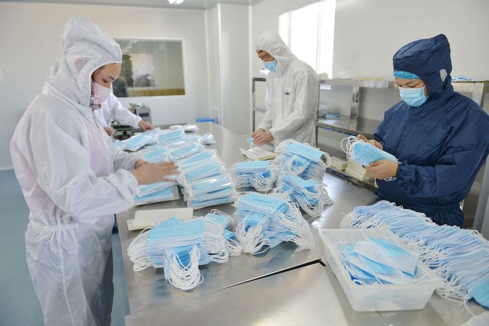 Arbeiders maken gezichtsmaskertjes in een fabriek in China.