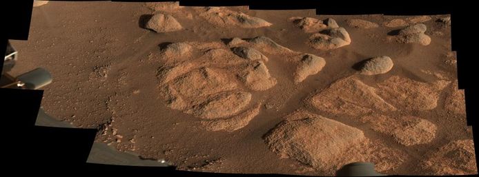 Dit beeld werd gemaakt uit 21 aparte foto's die de Marsrover nam van de bodem van Mars. De kleur benadert de echte kleur die te zien is op onze buurplaneet. Om een idee te geven van de schaal: de grootste rots die een schaduw werpt rechtsboven in beeld is ongeveer 27 centimeter groot. Het volledige beeld heeft een doorsnee van drie meter.