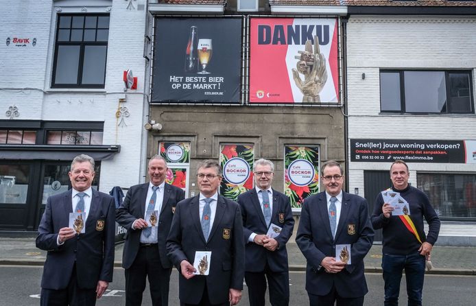 Het bestuur van de Orde van de Ezel, met 'danku'-kaartjes in de hand. Op de achtergrond een banner van drie op drie meter, op het Marktplein.