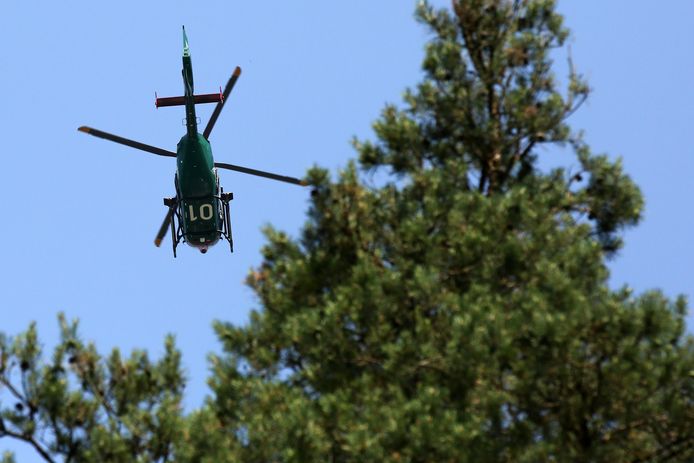 Een politiehelikopter vliegt over een bos in  de Duitse deelstaat Mecklenburg-Vorpommern heen.