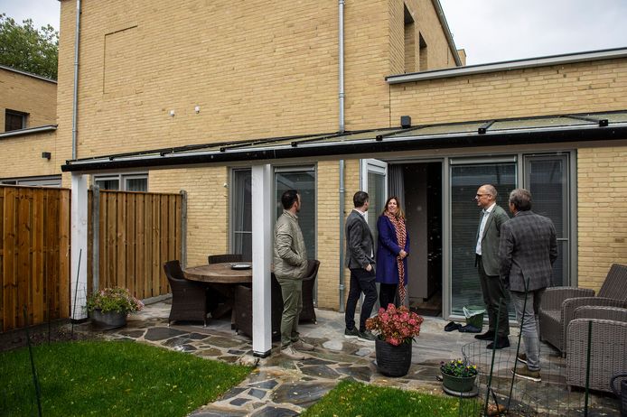 Wethouder Sandra Diepstraten neemt met enkele bouwers en een bewoner een kijkje in een van de patiowoningen achter de voormalige Rabobank in Rijen.