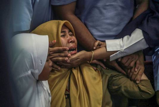 Huilende familieleden van inzittenden van vlucht JT610 op het vliegveld van Jakarta