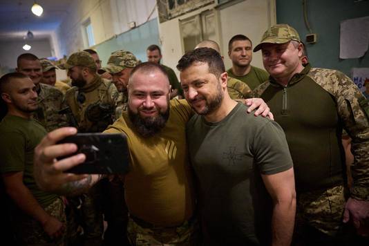 De Oekraïense president Volodymyr Zelensky poseert voor een selfie met enkele soldaten.