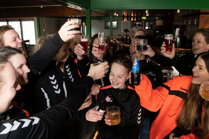 De volleybaldames van De Hooiberg zijn blij dat ze eindelijk in Olst het glas kunnen heffen na de wedstrijd, nu de sportkantine is heropend.