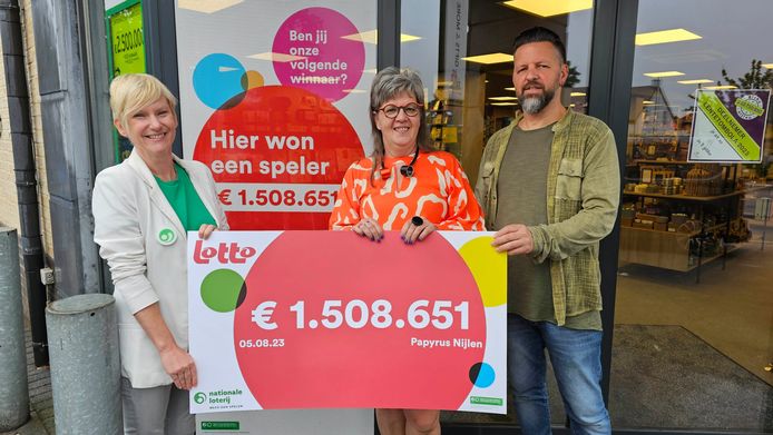 Liliane Goor van de Nationale Lotterij overhandigt een symbolische cheque aan Nadine Verstrepen en Joeri Hoefkens van dagbladhandel Papyrus, waar de winnaars speelden.
