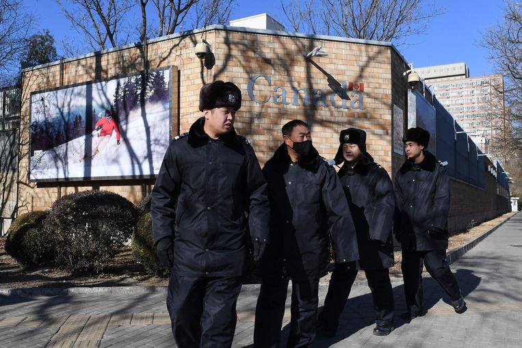 Chinese politieagenten patrouilleren voor de Canadese ambassade in Peking.  Beeld AFP