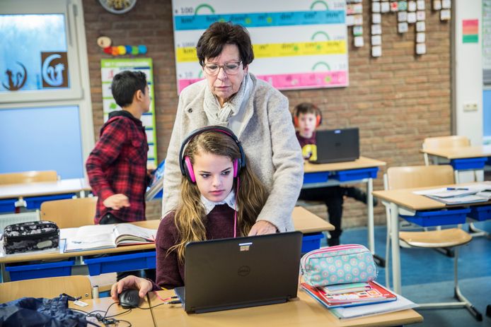 Een onderwijsassistent helpt een leerling. Is de Veluwe overbevolkt met onderwijsassistenten, vraagt Linda Oosterveen zich af.