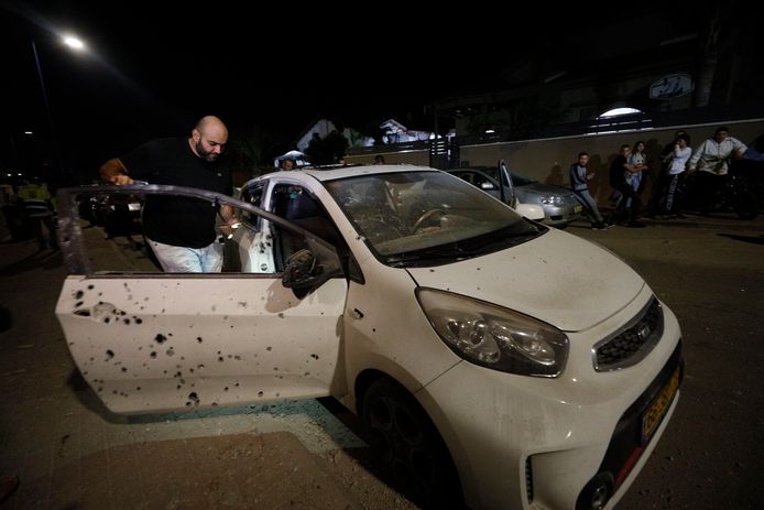 Een man meet de schade aan zijn auto op in Sderot.