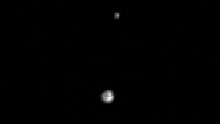 Pluto en de maan Charon, in 1997 gezien door de Hubble-telescoop. Beeld NASA
