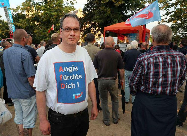 Een AfD aanhanger afgelopen donderdag in Schwerin met de tekst 'Angie wees bang' op zijn T-shirt. Beeld epa