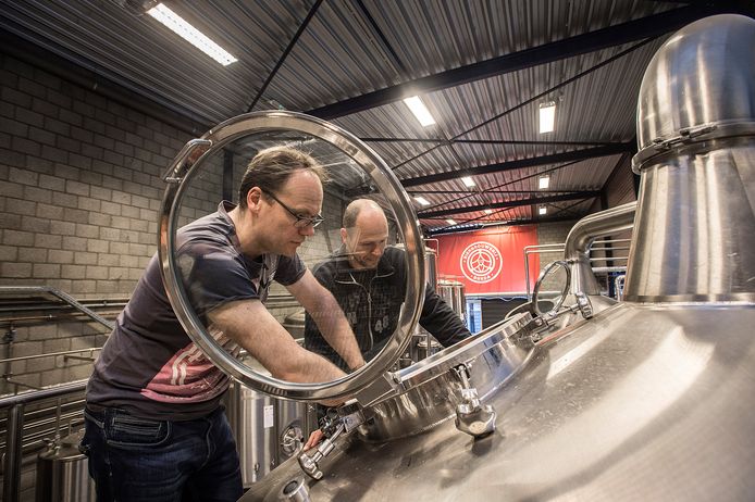 Niels de Vos van Bierbrouwerij Breda bekijkt samen met brouwer Joppe de Bres (rechts) een van de ketels.