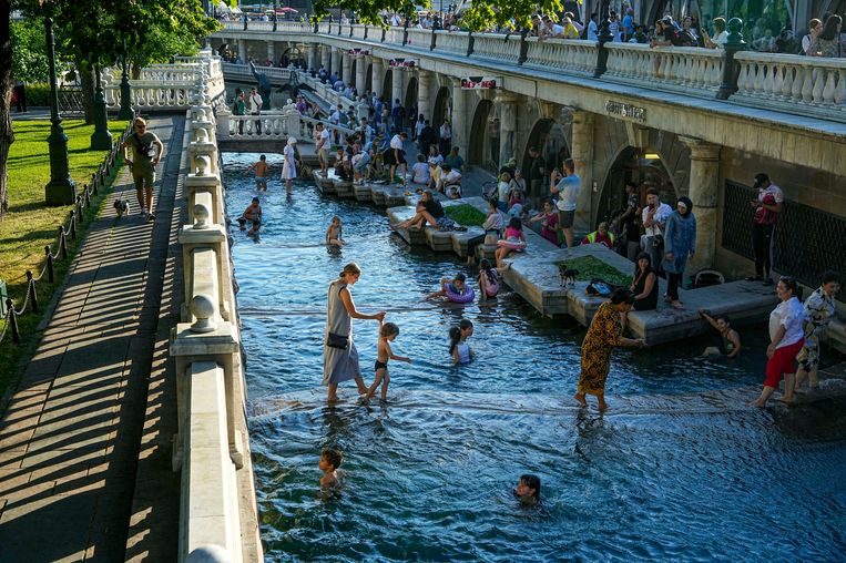 Семьи освежаются в реке Нехлинной, московском притоке, протекающем через Москву недалеко от Кремля.  Изображение от АП