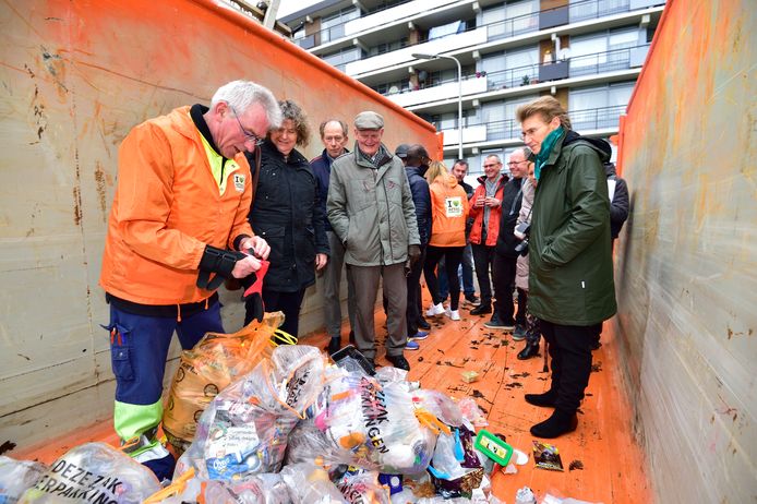 Maarten 'Milieu' van Cyclus pluist onder toeziend oog van de Goudse wethouder Hilde Niezen (GroenLinks) de zakken met plastic afval uit die net zijn geleegd vanuit de ondergrondse container op het Olympiadeplein.