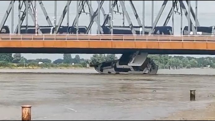 Un yacht de plaisance sous un pont.