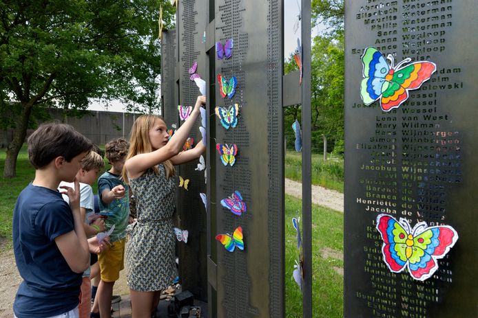 Kinderen uit groep 7 hangen vlinders in het hek en op het monument ter nagedachtenis aan de kindertransporten van Vught naar Sobibor.