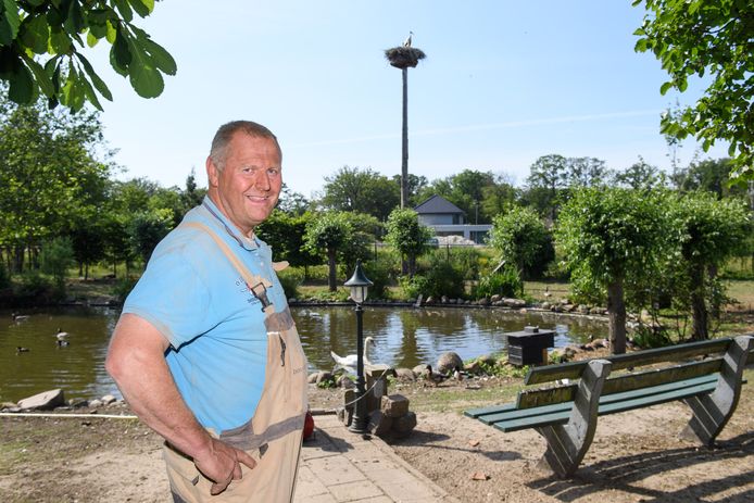 Wim Platenkamp met op de achtergrond de ooievaarspaal met de bijzondere bewoner Ollie.
