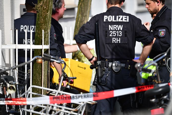 De Duitse politie draagt bewijsmateriaal uit het huis van de dader naar buiten.