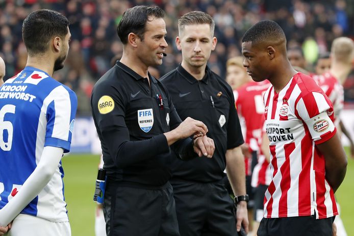 Denzel Dumfries is voor het duel met Heerenveen voor het eerst aanvoerder van PSV.  Scheidsrechter Bas Nijhuis licht nog even toe hoe de toss werkt.