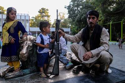 Talibanstrijders poseren met kalasjnikovs voor groepsfoto’s in dierentuin Kaboel