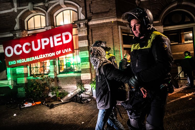 UvA-Studenten worden in januari door de politie ontruimd uit het Binnengasthuis, dat ze bezetten uit protest tegen de banden met de fossiele industrie van de universiteit. Beeld Joris van Gennip