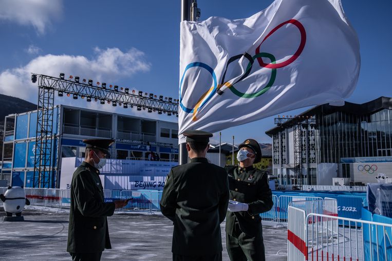 Soldaten van het Chinese leger repeteren het hijsen van de olympische vlag in het atletendorp van Zhangjiakou. Beeld Getty Images