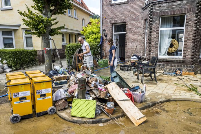 Inwoners ruimen puin na de wateroverlast in Valkenburg aan de Geul. De hevige regenval en overstromingen in Limburg hebben voor veel schade gezorgd.