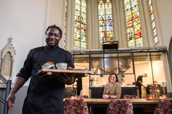 Kok Jozef Dinge in restaurant Onze Kerk. Op de achtergrond kijk eigenaar Dieuwke Stellinga toe.