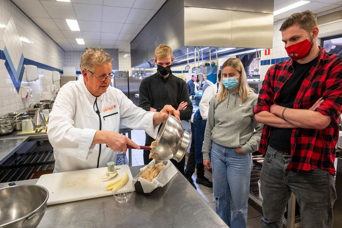 Erik te Velthuis legt aan drie studenten van Rijn IJssel eet hoe je de populaire en gezonde bananencake maakt.