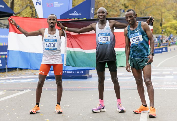 Abdi Nageeye met de Nederlandse vlag. Naast hem winnaar Evans Chebet en Shura Kitata, die derde werd.