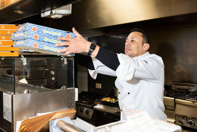 Ayman Khallaf haalt de dozen voor de pizza’s vast tevoorschijn. Zijn zaak mag weer open.