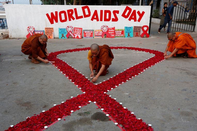 Boeddhistische monniken in India steken kaarsen aan tijdens Wereldaidsdag.  Beeld REUTERS