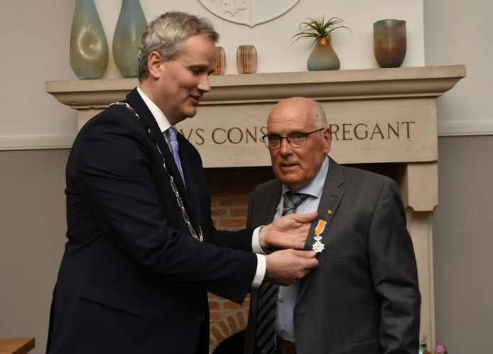 Burgemeester Evert Weys (l) speldt de koninklijke onderscheiding op bij Cees van Hoof.