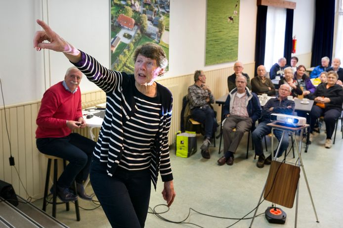 Ida Verhoeven (rechts) wijst een bekende aan op een oude foto. Links kijkt Leo Swaans toe.