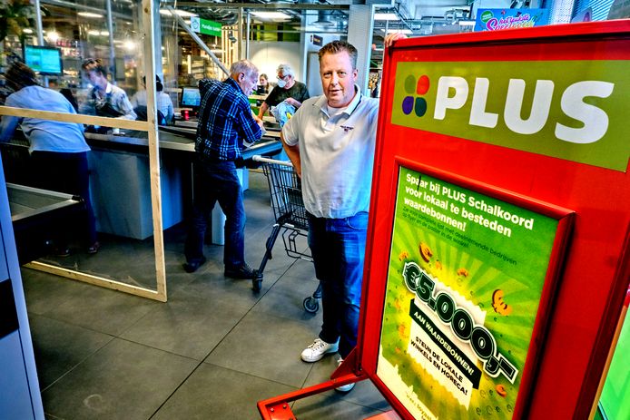 Mario van der Linden van PLUS Schalkoord attendeert op het enorme bord om lokale ondernemers in NIeuw-Beijerland te steunen.