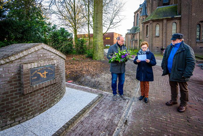 Het oorlogsmonument van Sint Willebrord staat nu op zijn definitieve plaats achter de kerk. Ceremoniemeester Nelly Roks leest voor wat het monument verbeeldt. Links wethouder René Lazeroms, rechts Wim Roelands.