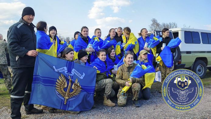 Vrijgelaten Oekraïners poseren met Oekraïense vlaggen.