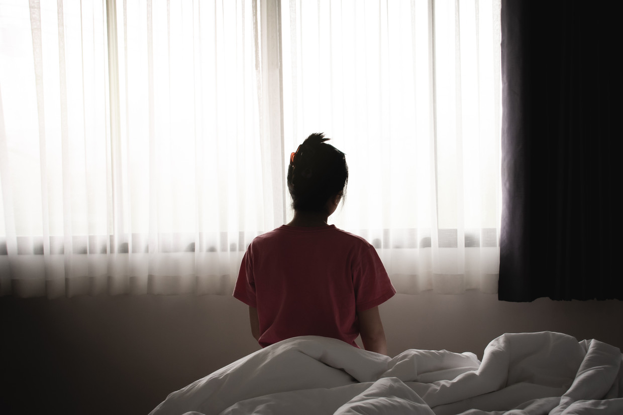 Depressed asian woman has sad and lonely feel sitting on the bed in the morning.