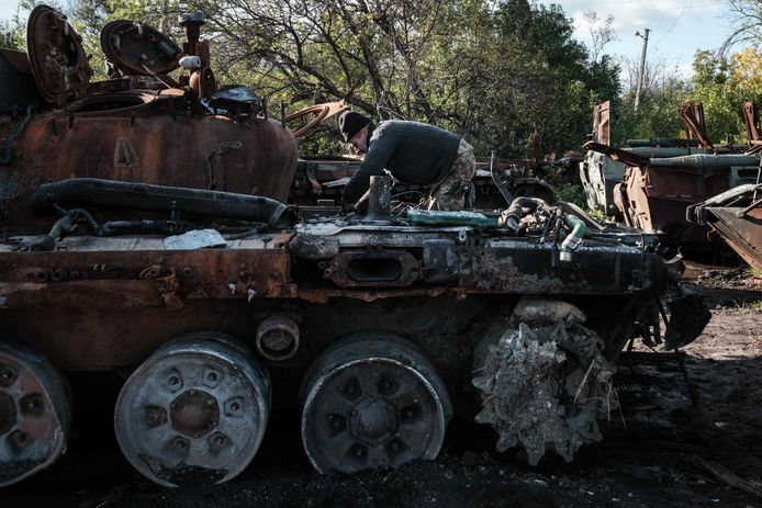 Un soldato volontario ucraino e un ex meccanico ispezionano un carro armato russo abbandonato in un punto di raccolta per veicoli militari russi disabili vicino a Izyum.  Foto del 25 settembre.