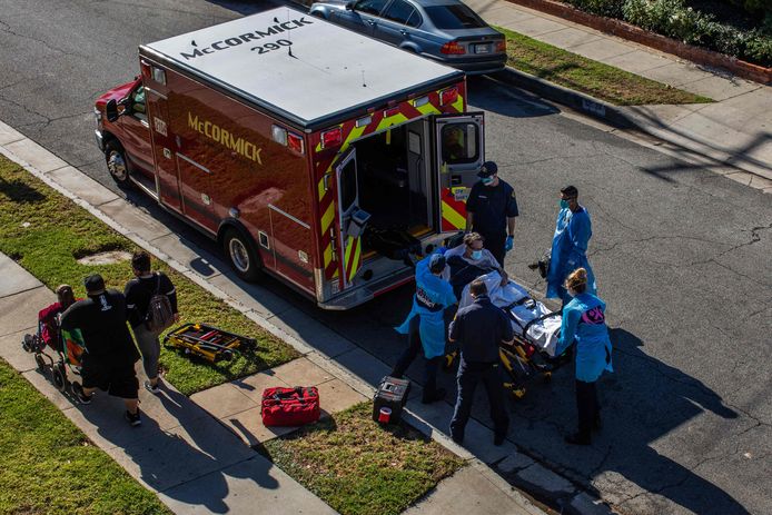 Een mogelijke patiënt met Covid-19 wordt in een ambulance geladen in LA County.