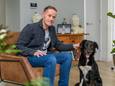 John van den Hoven met hond Kyra. Op de achtergrond de foto van zijn overleden vrouw Conny.