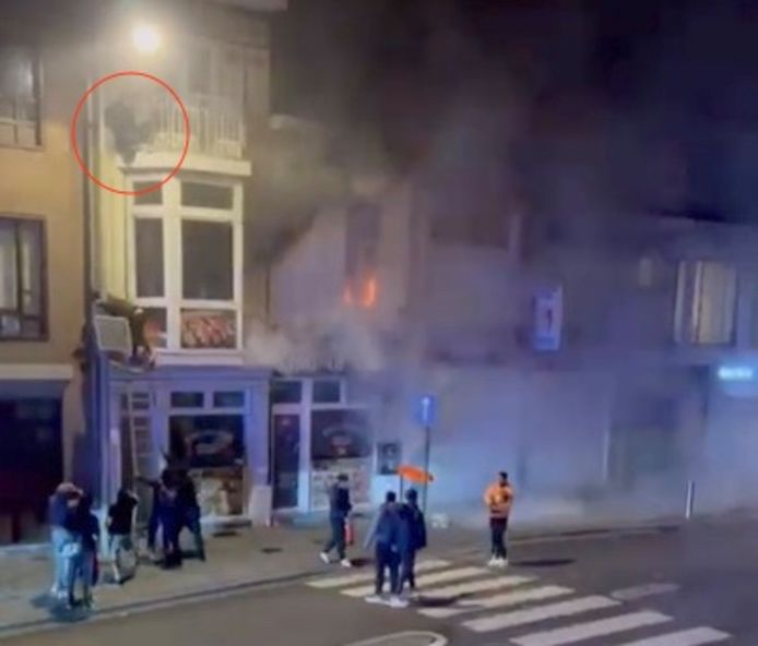 Paniek in de Zwevegemsestraat in Kortrijk: een man (rood omcirkeld) kan geen kant uit terwijl schuin onder hem een uitslaande brand woedt. Passanten plaatsten een ladder maar die bleek niet hoog genoeg. Uiteindelijk kon de man gered worden met een langere ladder, van de brandweer.